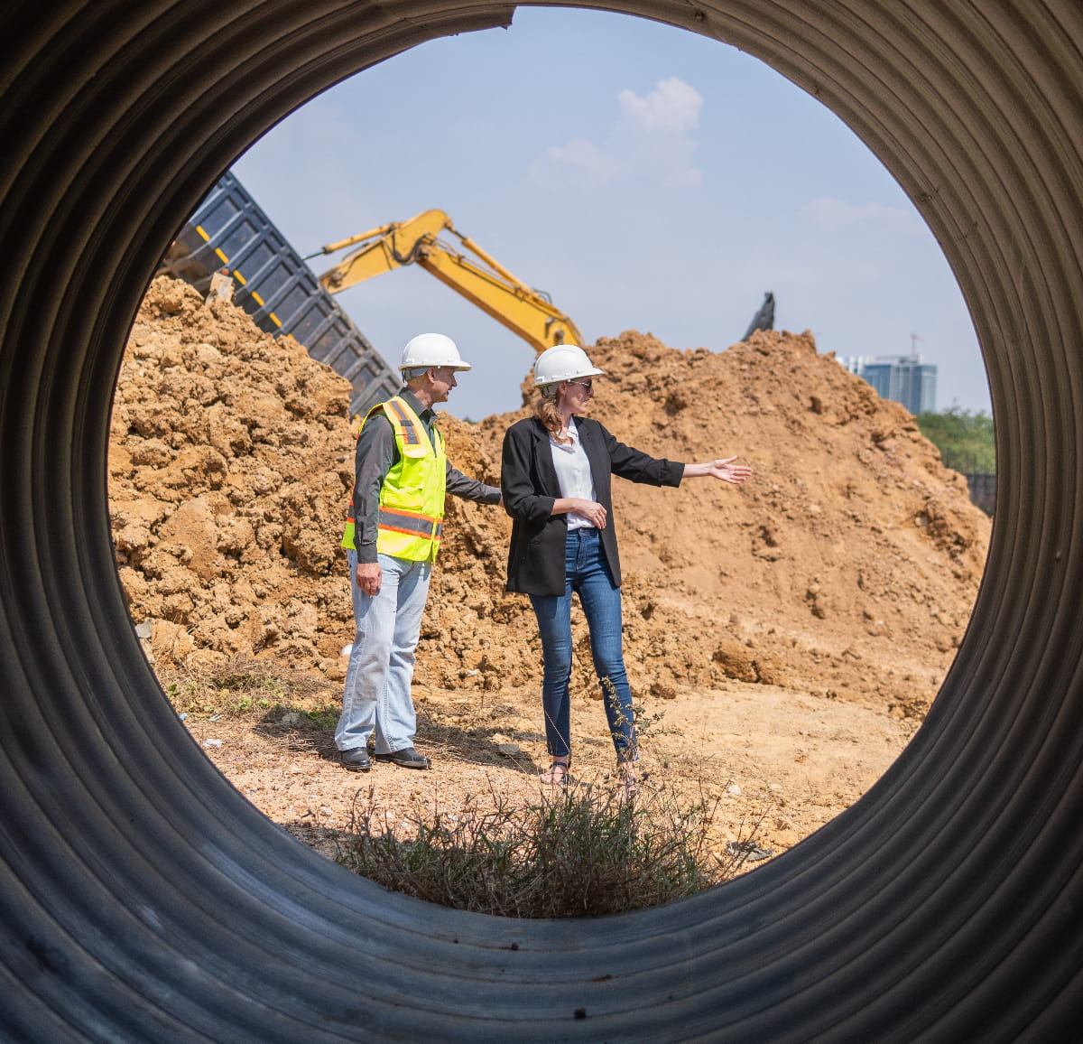 Manager and engineer talking neat unburied Industrial pipeline used for public sector infrastructure.