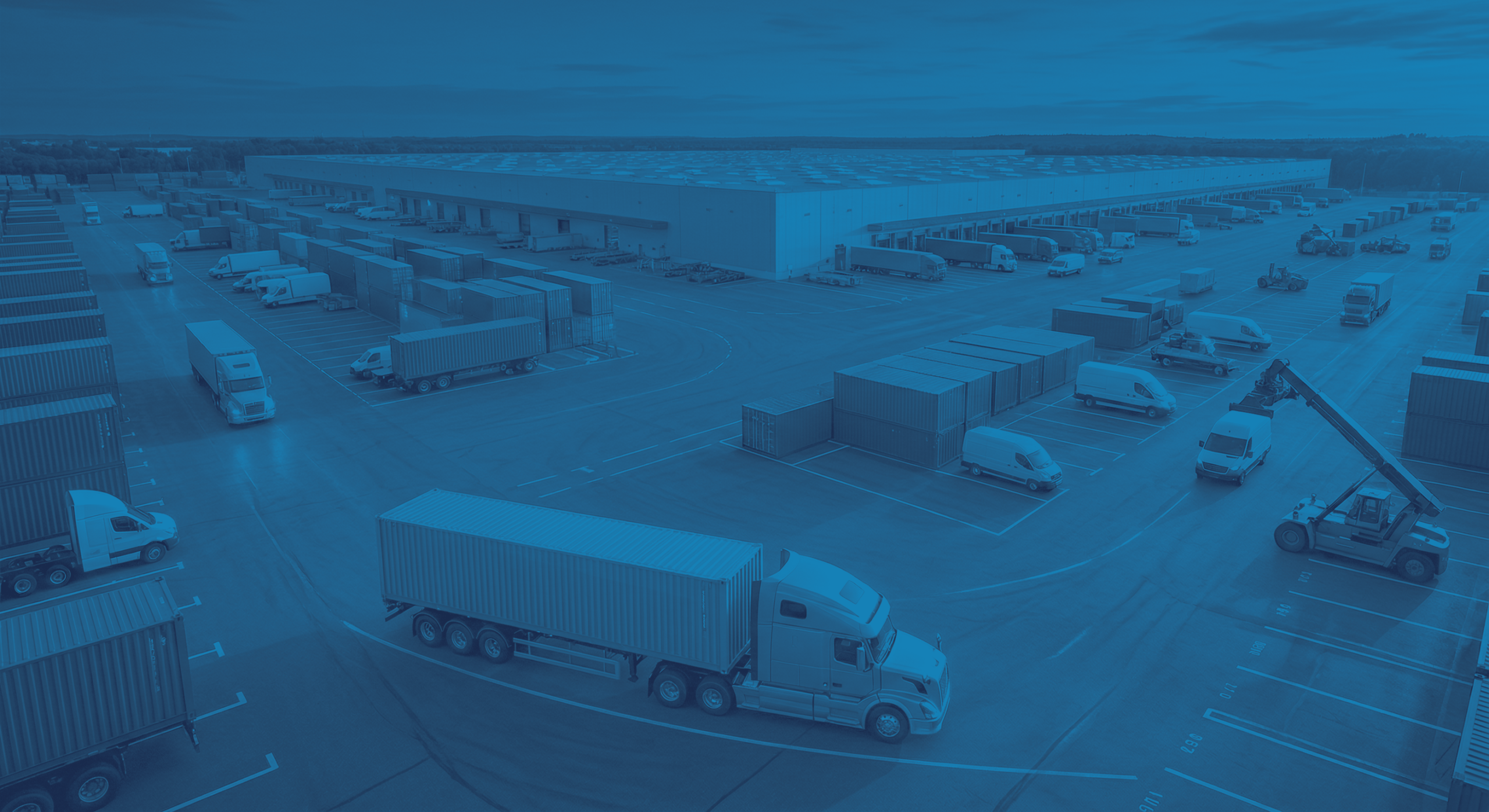 Aerial view of a logistics yard with trucks and shipping containers